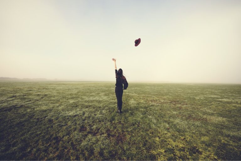 Letting Go Endowment Effect Woman Tossing Hat In Field