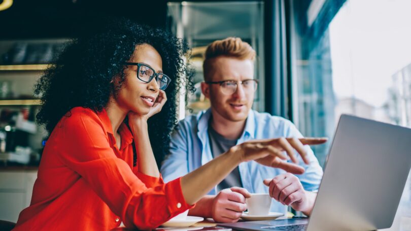 Coworkers Discussing Soething On The Laptop Coffee Shop