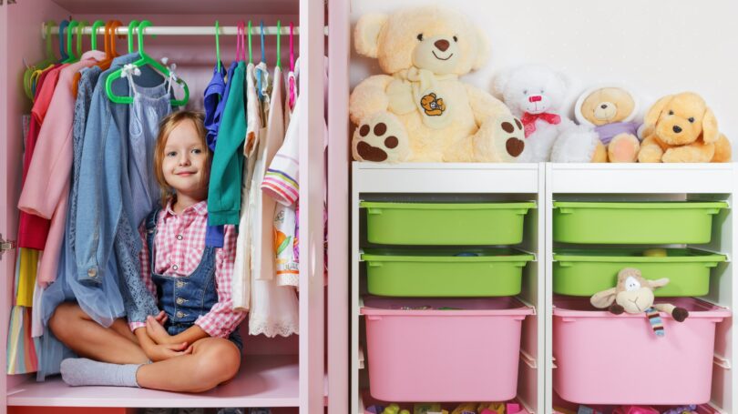 Little Girl Sitting In Wardrobe Closet Clean Organized