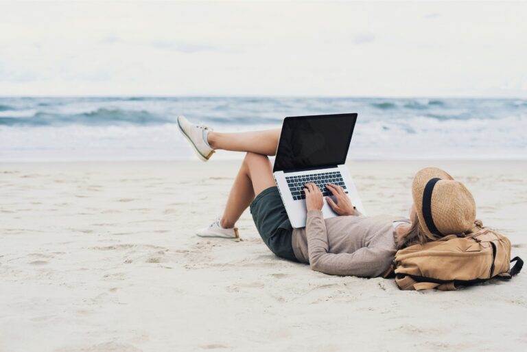Woman Using Laptop Working From Beach
