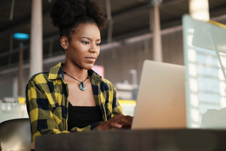 Woman Working On Laptop Computer In Library