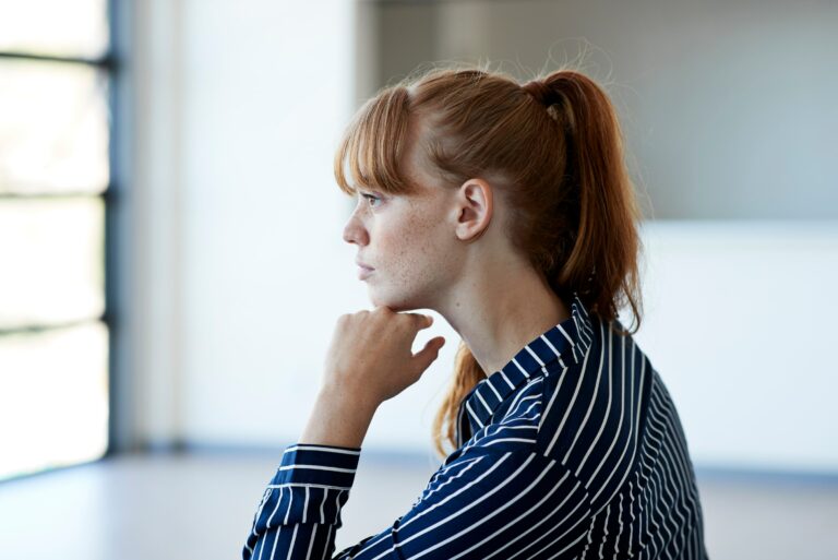 Young Woman Thinking While Outside Window